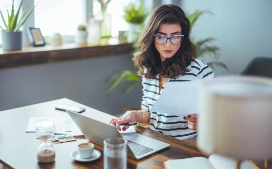 Femme qui prépare des bulletins de paie sur son ordinateur