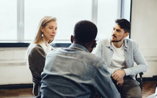 Trois personnes autour d'une table pour un entretien annuel individuel