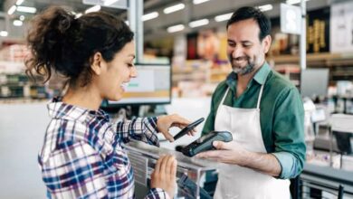 Un commerçant encaisse une cliente