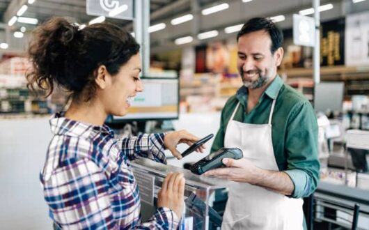 Un commerçant encaisse une cliente