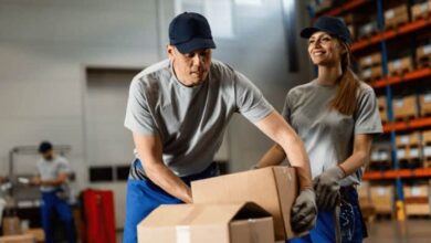 Un homme et une femme chargent des cartons dans un entrepôt