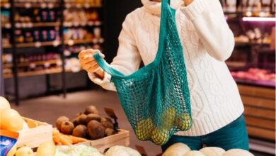 Un client achète des fruits et légumes dans une boutique avec un contenant réutilisable