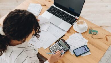 Une femme devant son ordinateur et sa calculatrice sur la gestion des immobilisations