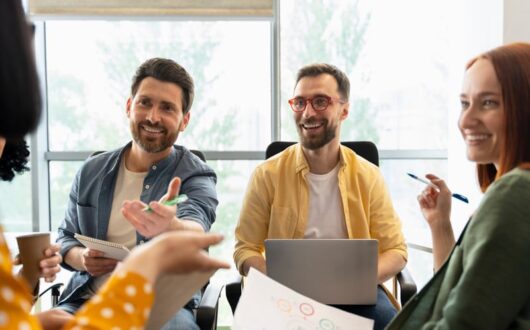 Des collaborateurs échangent en souriant