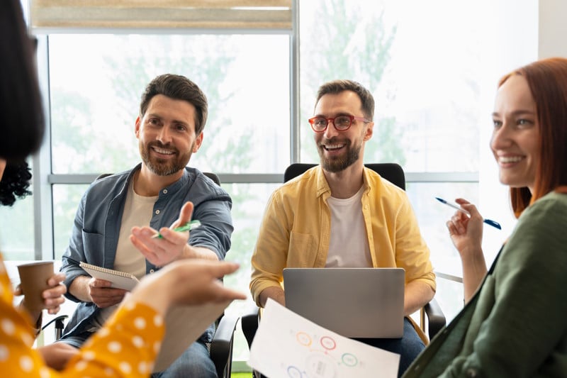 Des collaborateurs échangent en souriant