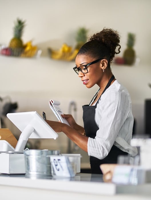 Commerçante qui encaisse un client sur un logiciel de caisse moderne