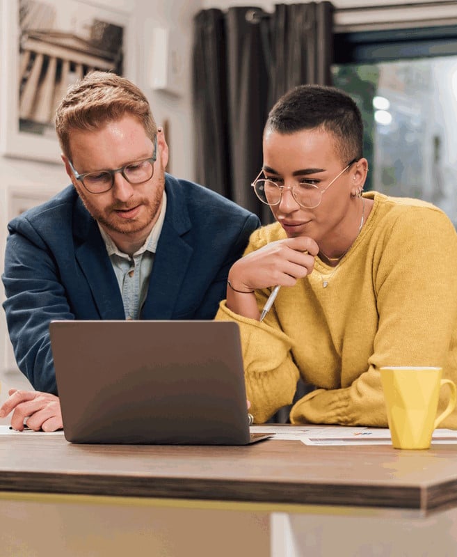 Une homme et une femme regardent leur logiciel de paie Silae sur ordinateur