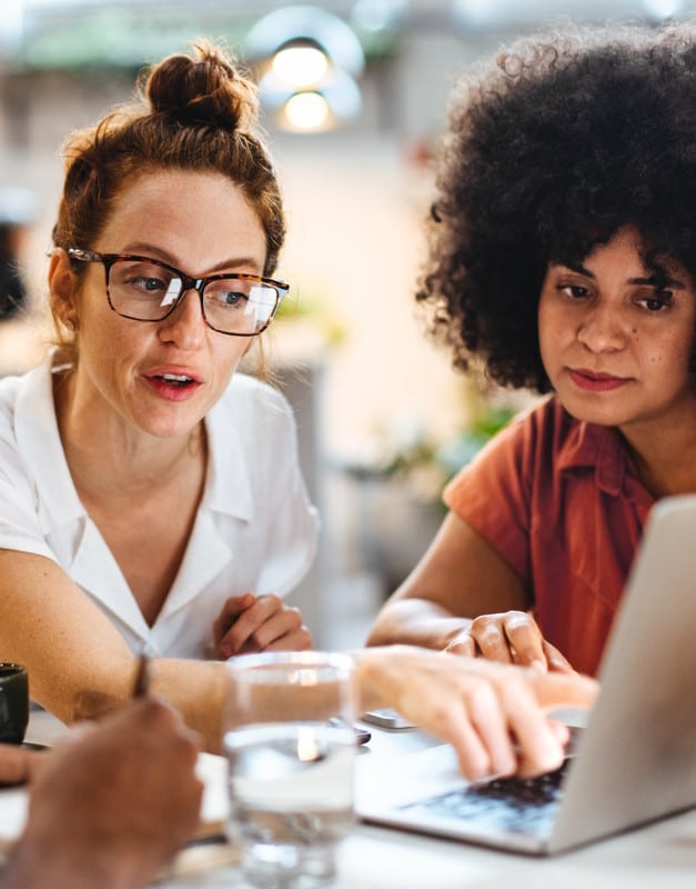 Deux femmes regardent l'écran de leur logiciel SIRH