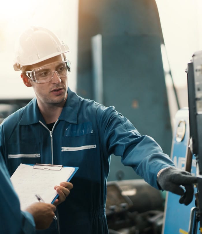 Un technicien en travail, avec combinaison et casque