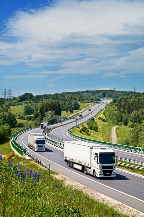 Des camions sur la route dont l'itinéraire est optimisé par un logiciel TMS