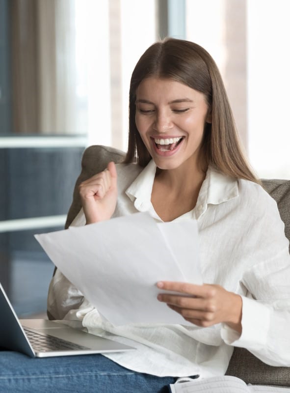 Une femme tient en main une fiche de paie générée rapidement avec son logiciel de paie